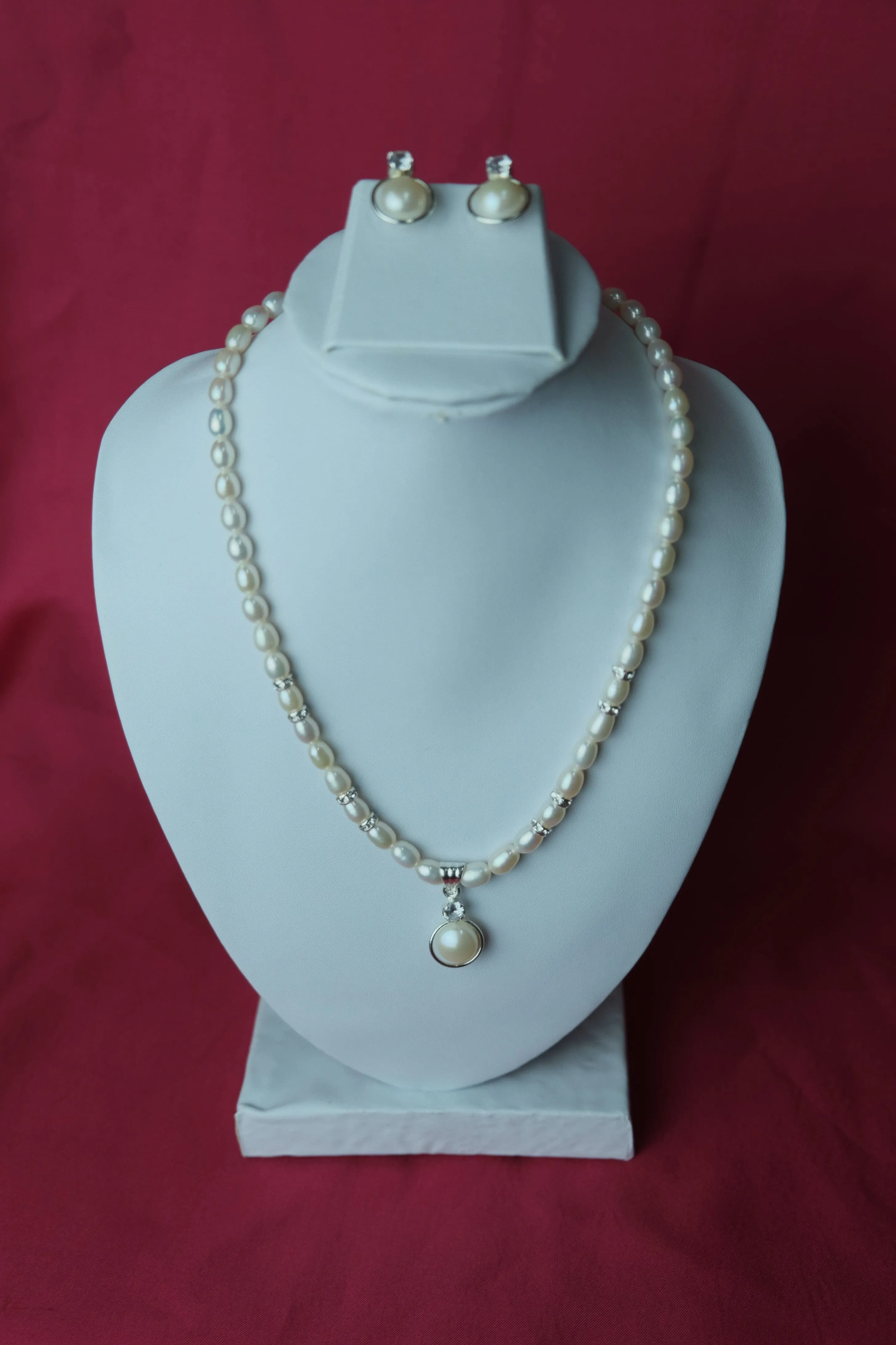 White color single line medium size fresh water cultured pearl necklace with pearl pendent along with jhumkas.